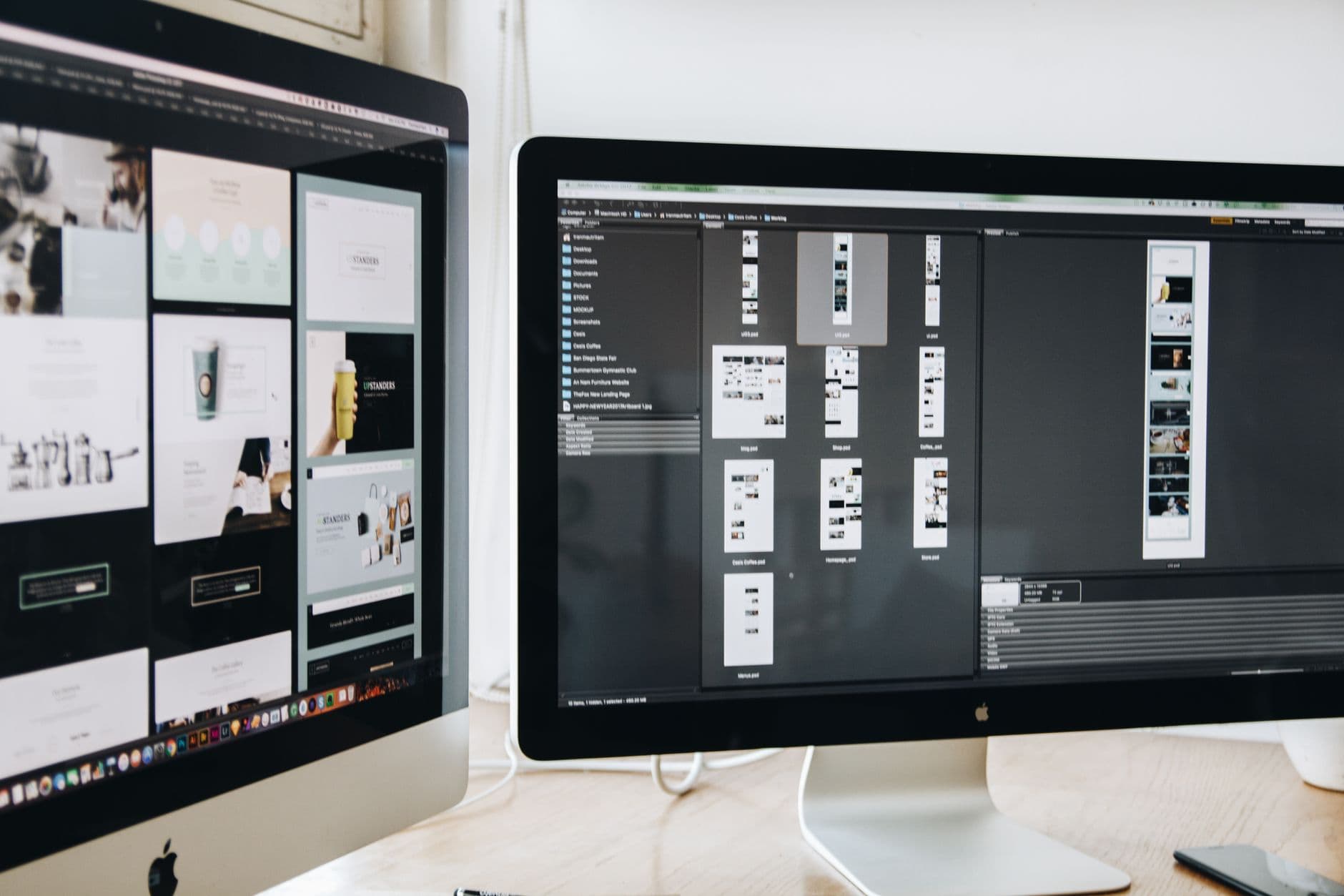 Two monitors showing website layouts being designed